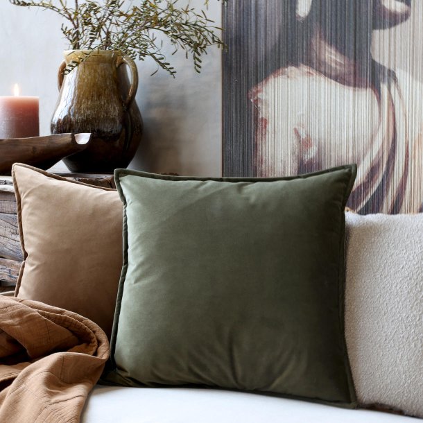 Velourpudebetr�k i oliven p� sofa