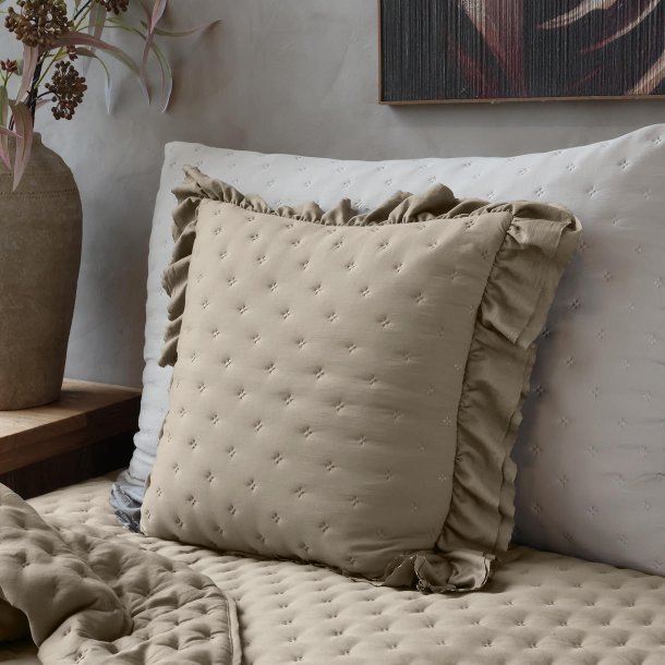 Pudebetr�k med fl�sekant i latte p� sofa