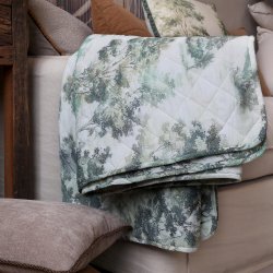 Quilt med landskabsprint i creme og oliven p� sofa