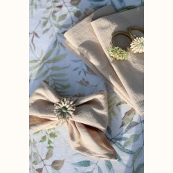 detalje af servietring med blomsterdesign i creme