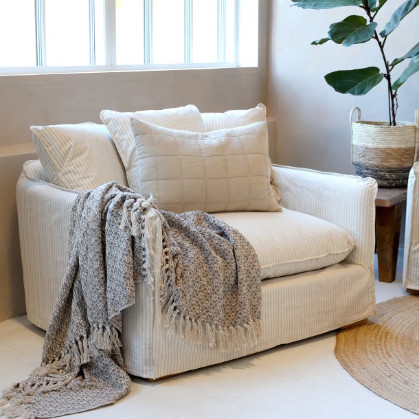 l�n stol i h�r med puder placeret i stue med t�ppe