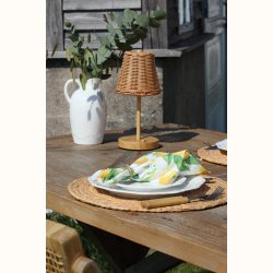 Opladelig bordlampe i rattan p� terrassebord med hyggelig belysning